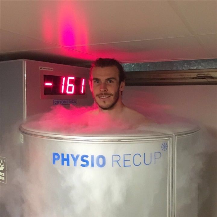 Person standing in a cryotherapy chamber with temperature display reading -161 degrees, surrounded by mist.